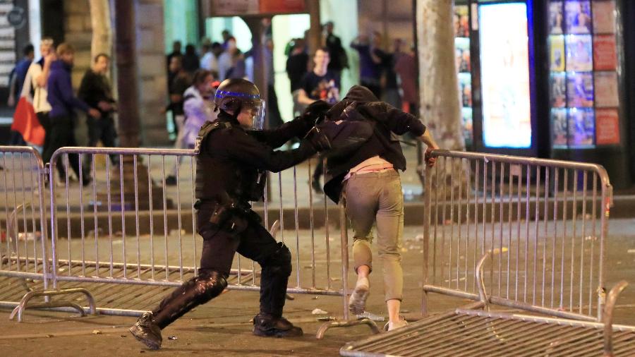 Policial agarra torcedor durante confusão em Paris, na França, após festa por classificação à final da Copa - REUTERS/Gonzalo Fuentes