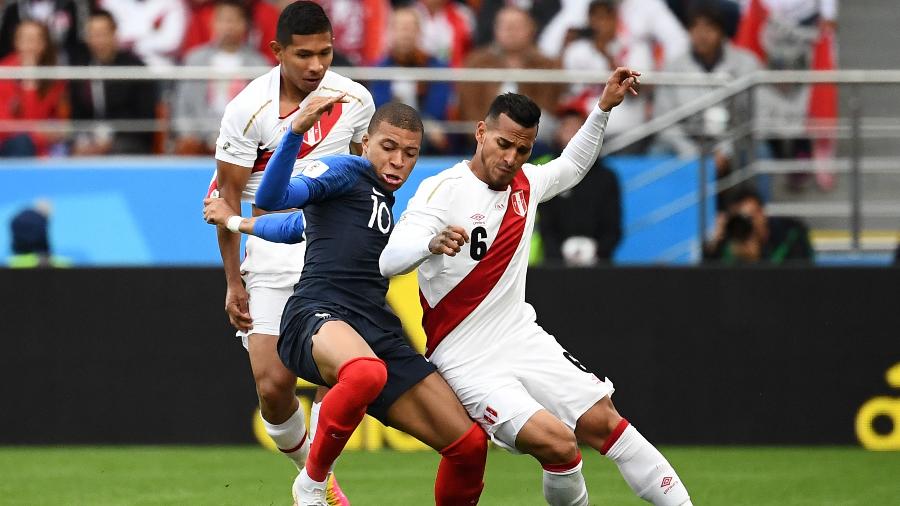 Miguel Trauco, do Peru, disputa bola com Kylian Mbappé, da França - FRANCK FIFE/AFP