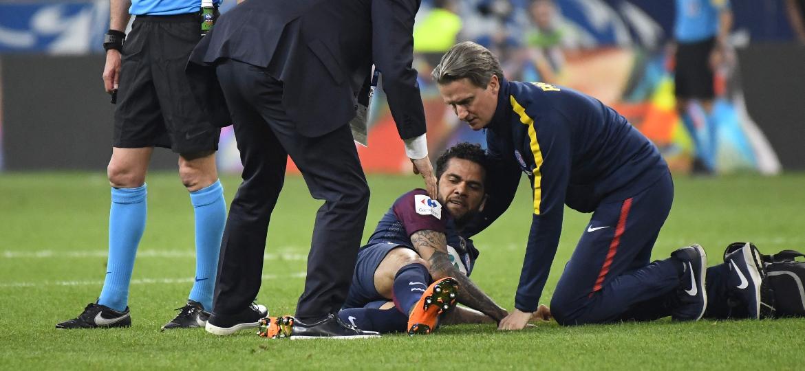 Daniel Alves é atendido pelo departamento médico do PSG na final da Copa da França, quando lesionou o joelho - AFP PHOTO / Damien MEYER