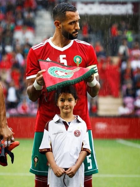 O zagueiro Benatia protege mascote da chuva no amistoso entre Marrocos e Eslováquia - Divulgação/Federação Marroquina de Futebol