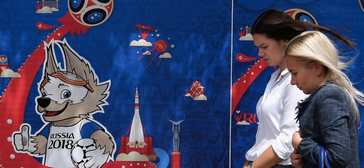 Duas russas passam em frente a pôster da Copa do Mundo - Stu Forster/Getty Images