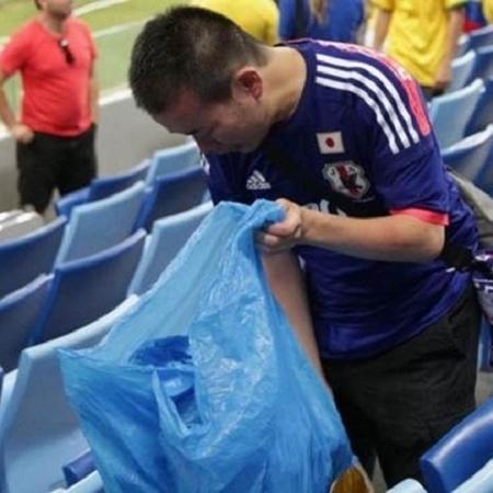Torcedor recolhe lixo de estádio após jogo do Japão na Copa de 2018; prática se repetiu em 2022, no Qatar - Getty Images