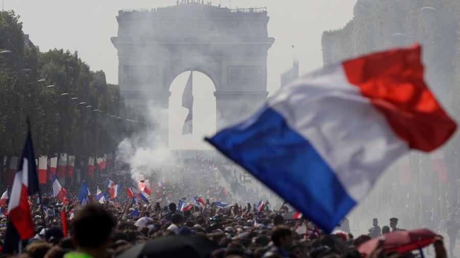 Torcedores franceses se espremem na Champs-Elysees para recepcionar os campeões do mundo - AFP PHOTO / Geoffroy VAN DER HASSELT