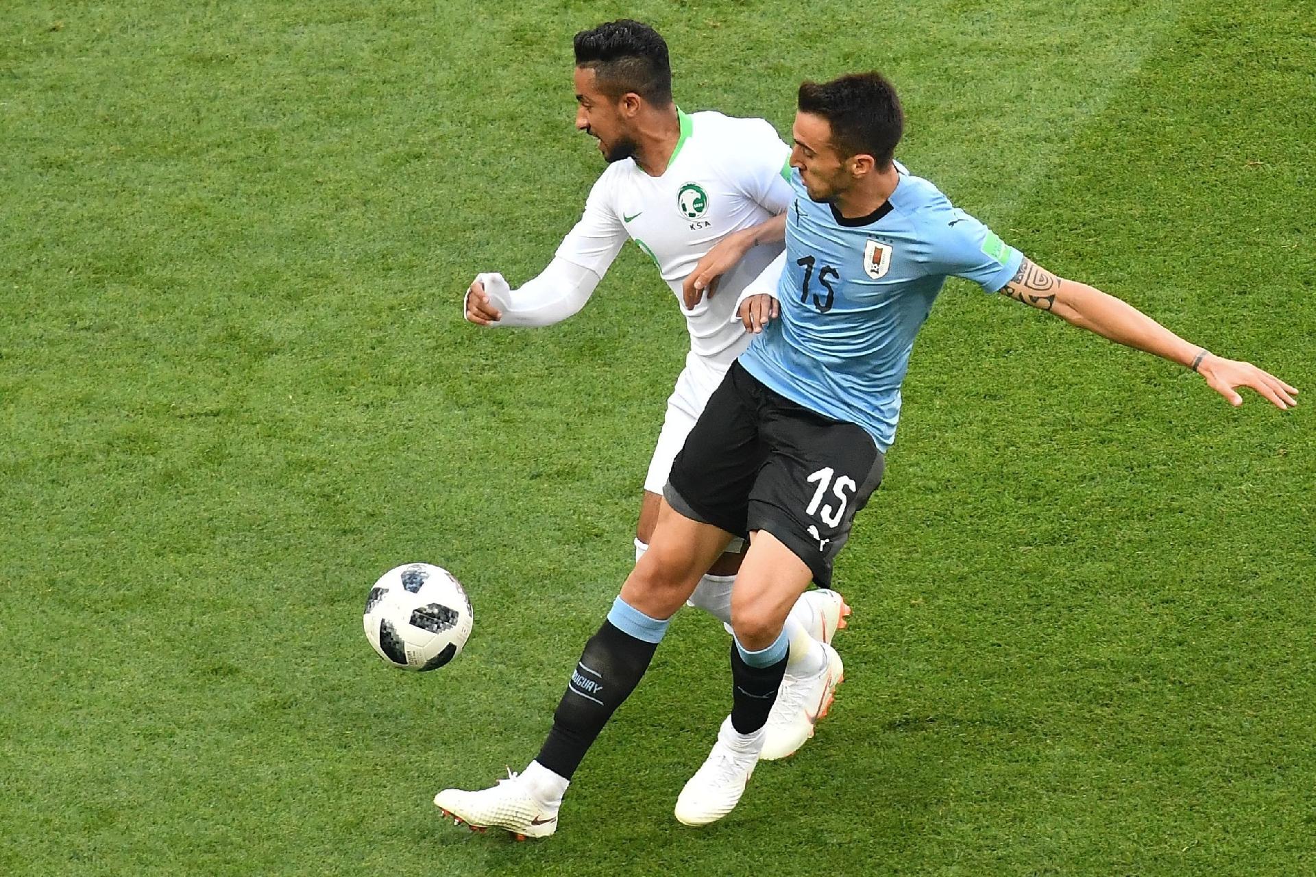 Hatan Babhir, da Arábia  Saudita, disputa bola com Matias Vecino, do Uruguai - JOE KLAMAR/AFP