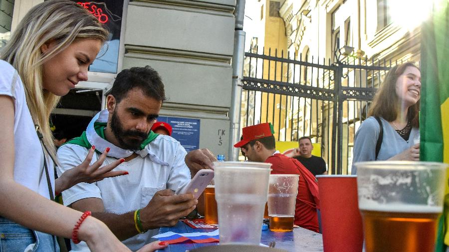 Um casal conversa enquanto bebe cerveja na Copa do Mundo da Rússia. Como será no Qatar? - VASILY MAXIMOV/AFP