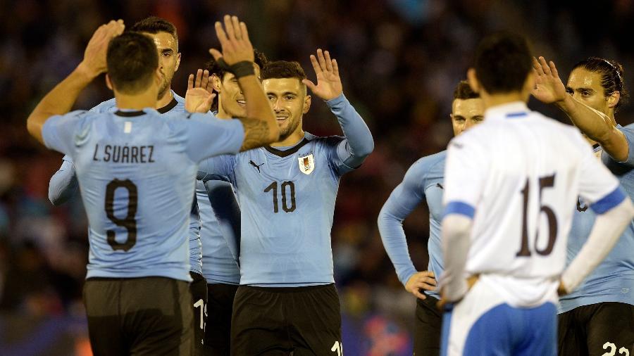Arrascaeta comemora com Luis Suárez o gol marcado pela seleção uruguaia - MIGUEL ROJO/AFP