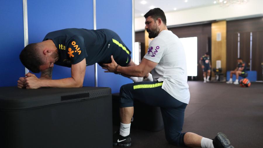Renato Augusto é auxiliado por Bruno Mazziotti durante atividade na academia em Sochi; Brasil teve problemas - Lucas Figueiredo/CBF