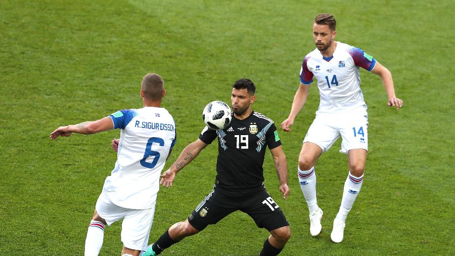 Aguero, da seleção da Argentina, domina a bola entre dois marcadores da Islândia - Clive Rose/Getty Images