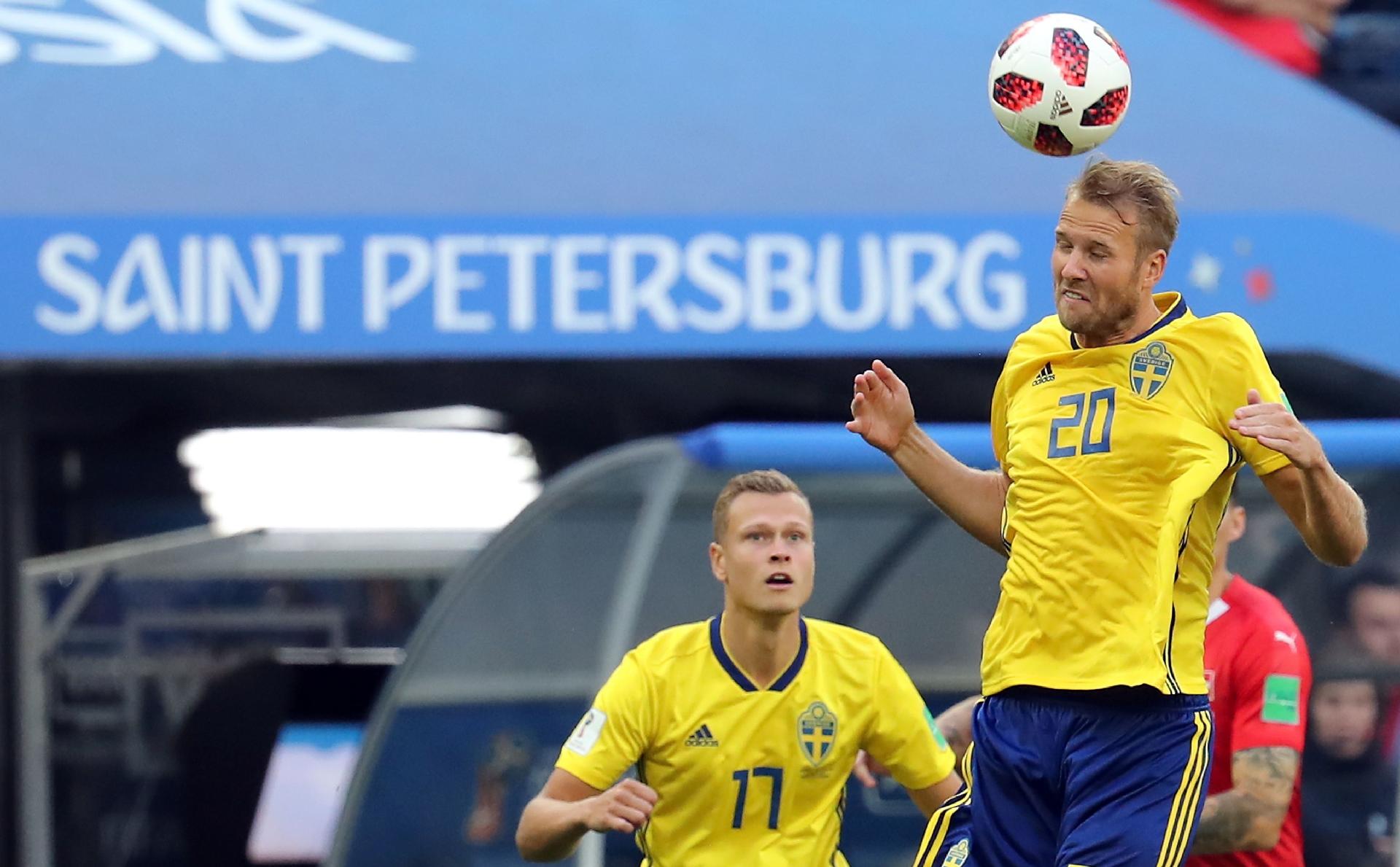 Ola Toivonen, da Suécia, cabeceia a bola no jogo contra a Suíça observado por Viktor Claesson - GEORGI LICOVSKI/EFE