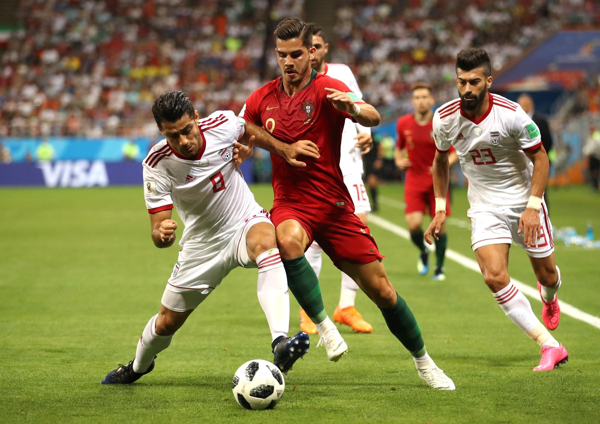 André Silva, de Portugal, é cercado por Ramin Rezaeian e Morteza Pouraliganji, do Irã - Clive Mason/Getty Images