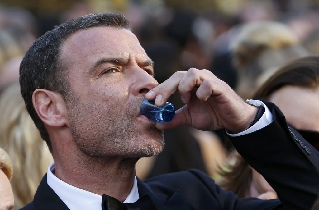 28.fev.2015 - Liev Schreiber toma um shot de bebida no tapete vermelho do Oscar - Ethan Miller/Getty Images/AFP