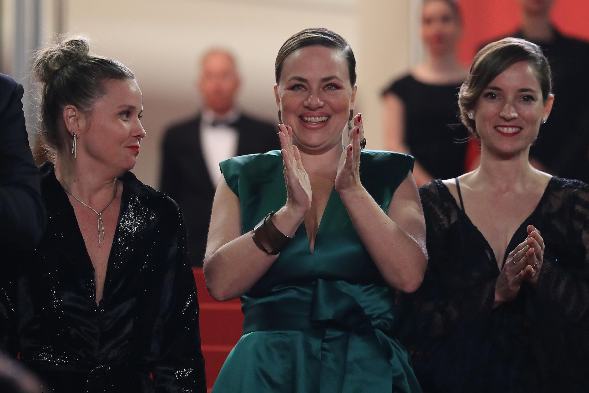 Pré-estreia de "Bacurau" em Cannes: Karine Teles (centro) aplaude ao lado da produtora francesa Emilie Lesclaux (direita) - Valery Hache/AFP