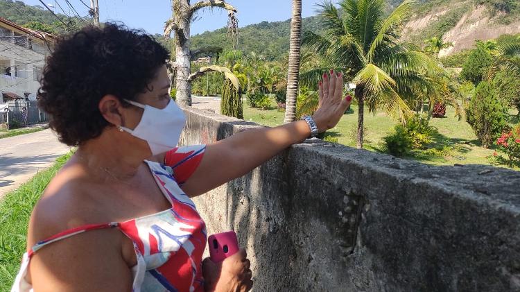 A aposentada Vera Lucia Ramos acompanha a chegada de familiares do humorista Paulo Gustavo pelo muro lateral do cemitério - Marcela Ribeiro/UOL - Marcela Ribeiro/UOL