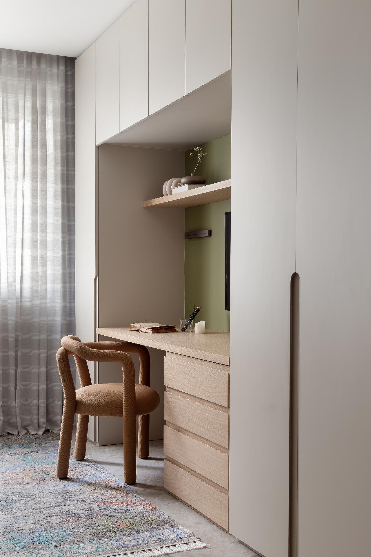 No estilo japandi, as tonalidades são suaves. A marcenaria foi desenhada pela arquiteta em tom areia na parte superior e madeira clara na parte inferior, com compartimentos desenhados para armazenar itens específicos, como vestidos de festa, equipamentos de ginástica e tábua de passar roupa. Pensar nos objetos que se tem facilita a organização de apês compactos. - Lilia Mendel/Divulgação