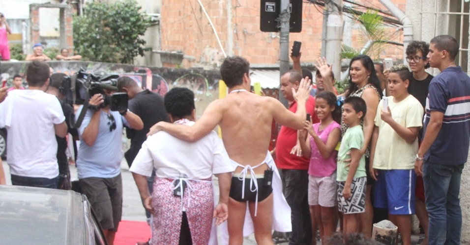 29.set.2015- Rodrigo Faro grava no Vidigal de avental e sunga e é cercado por moradores
