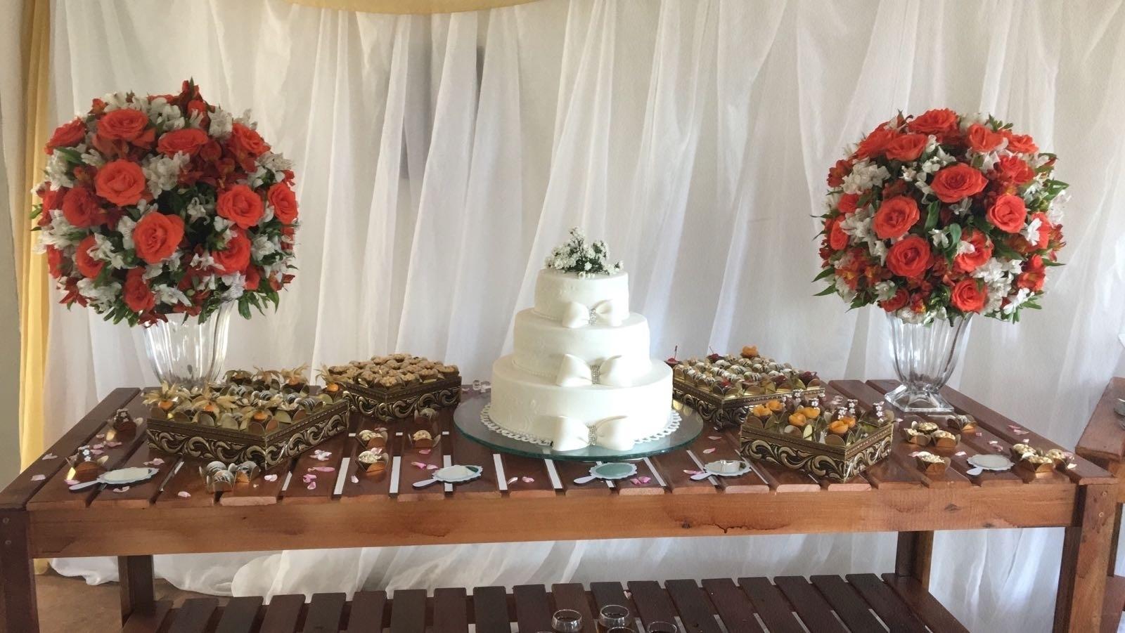 Uma bonita mesa de doces com o bolo de três andares e arranjos de flores espalhados pelo salão deram um toque de classe ao evento - Divulgação