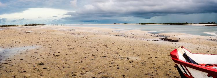 Salinópolis ou Salinas no Pará - panoramic HDR view.  Wide landscape dramatic clouds sky over beach with bow of wooden boat in foreground at sunrise blue hour - wagnerokasaki/Getty Images/iStockphoto - wagnerokasaki/Getty Images/iStockphoto