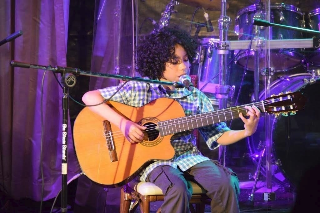 Felipe Machado canta e toca violão durante turnê no Japão, em 2014 - Reprodução/Facebook