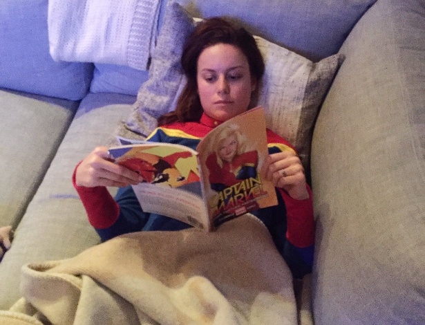 Caracterizada com o uniforme da Capitã Marvel, Brie Larson lê gibi da heroína que vai interpretar no cinema - Reprodução/Twitter/brielarson