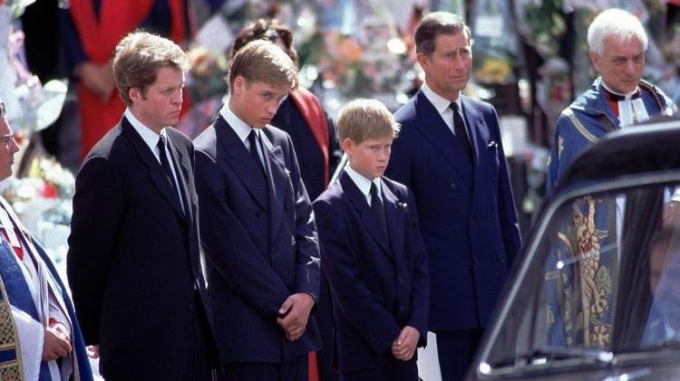 Príncipe Harry ficou ao lado do pai, príncipe Charles, e do irmão mais velho, príncipe William, enquanto viam o carro fúnebre carregar o caixão de Diana - BBC - BBC