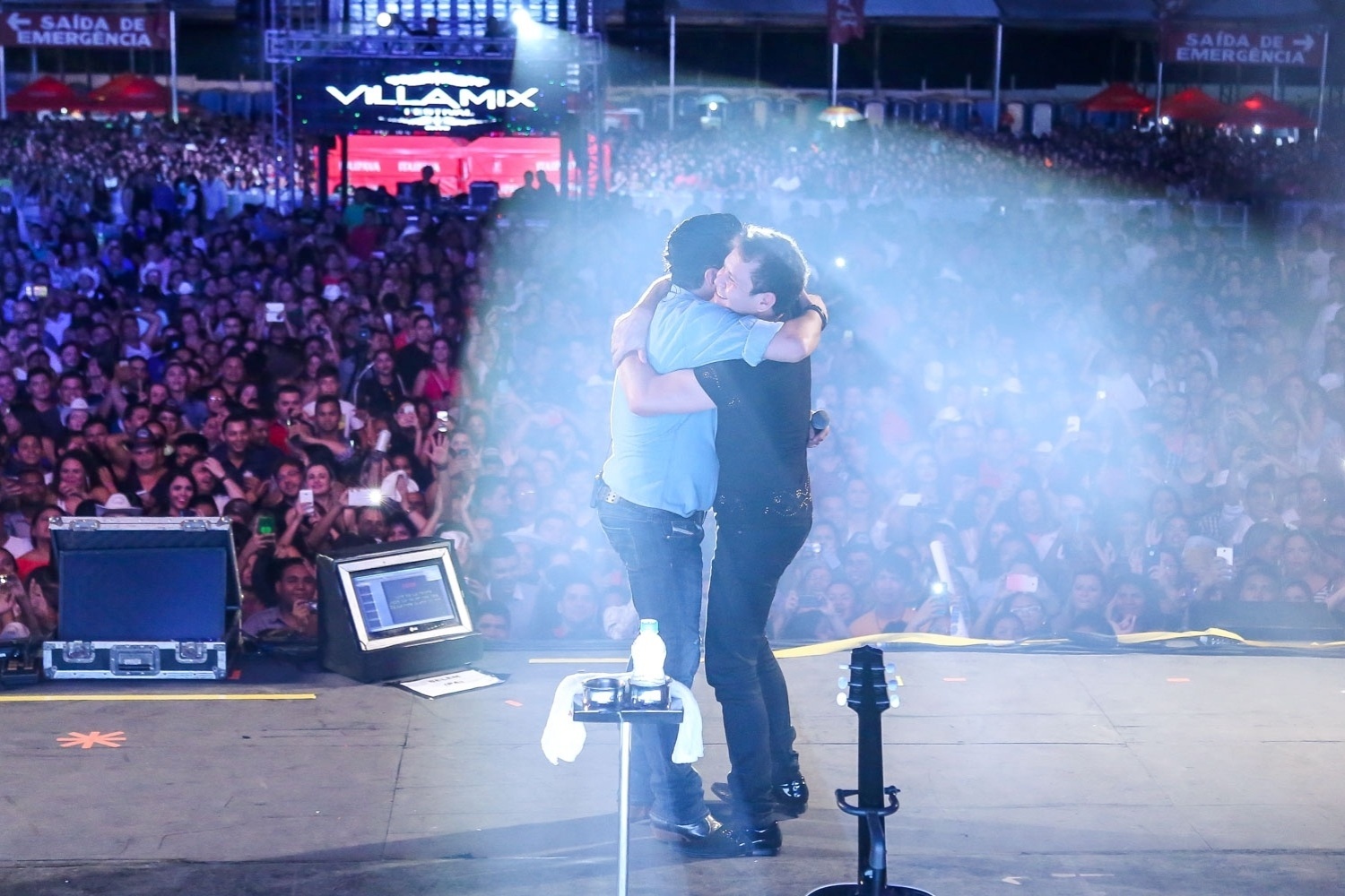 20.nov.2015 - O guitarrista Chimbinha, da banda Calypso, é chamado ao palco do festival Villa Mix e abraça Bruno - Caio Duran / Azzi Agency / Divulgação