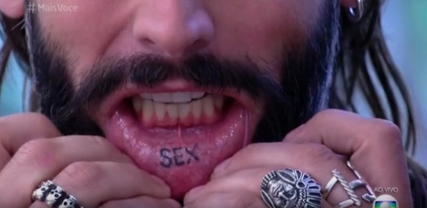 24.ago.2016 - Henri Castelli mostra a tatuagem 'sex' no lado interno de seu lábio inferior, no "Mais Você" - Reprodução/GShow - Reprodução/GShow