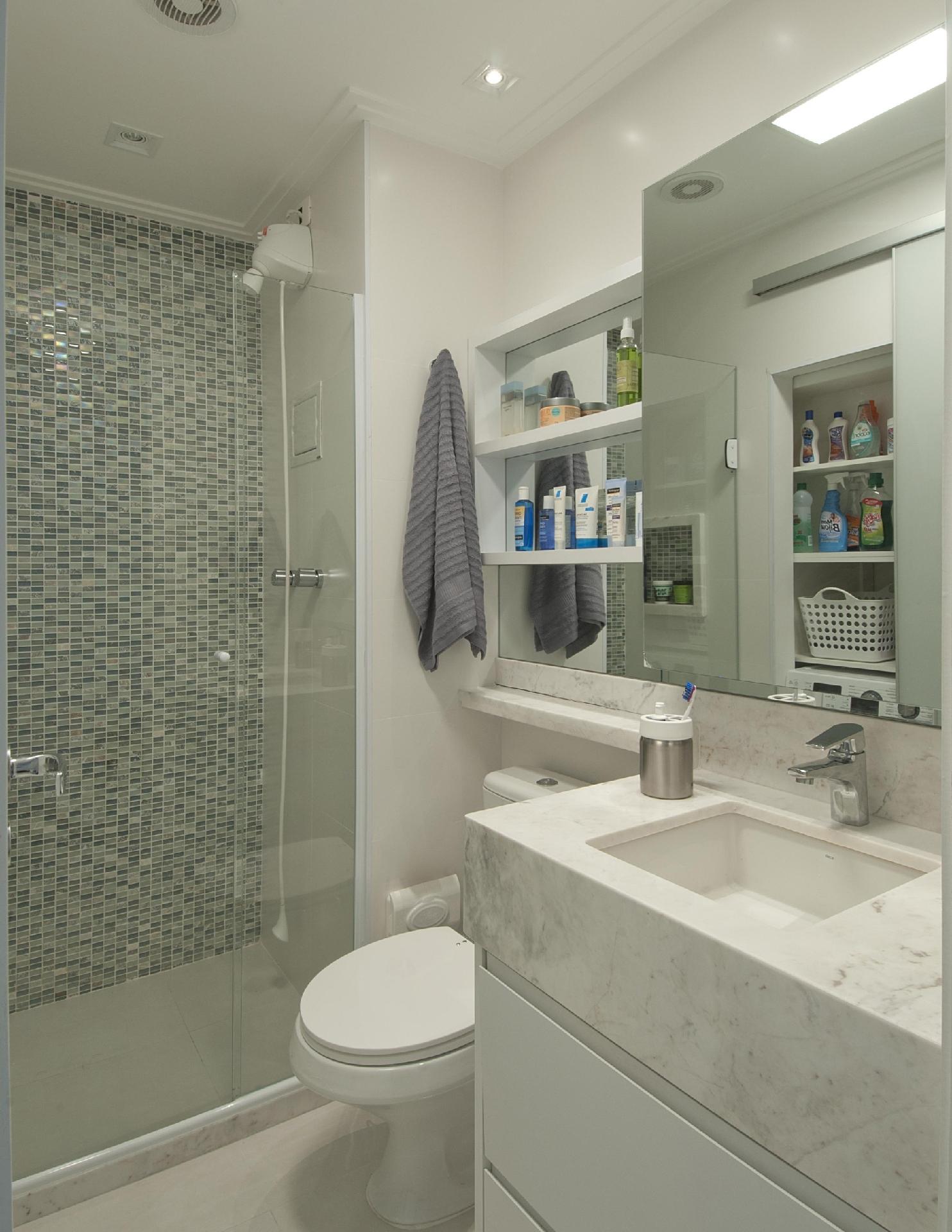 Nenhum centímetro foi desperdiçado no ambiente de 2,61 m². Os arquitetos Renato Andrade e Érika Mello, da Andrade & Mello Arquitetura, investiram em tons neutros para fazer o espaço parecer maior. Na parede acima do vaso sanitário, a dupla preencheu com um armário estreito. O fundo de cada prateleira é espelhado, que juntamente com o armário sobre pia ajuda a trazer amplitude - Luis Gomes | Divulgação