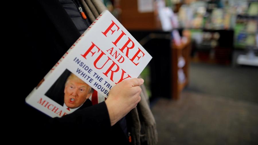Mulher segura o livro "Fogo e Fúria", de Michael Wolff, em uma loja em Washington DC - Carlos Barria/ Reuters