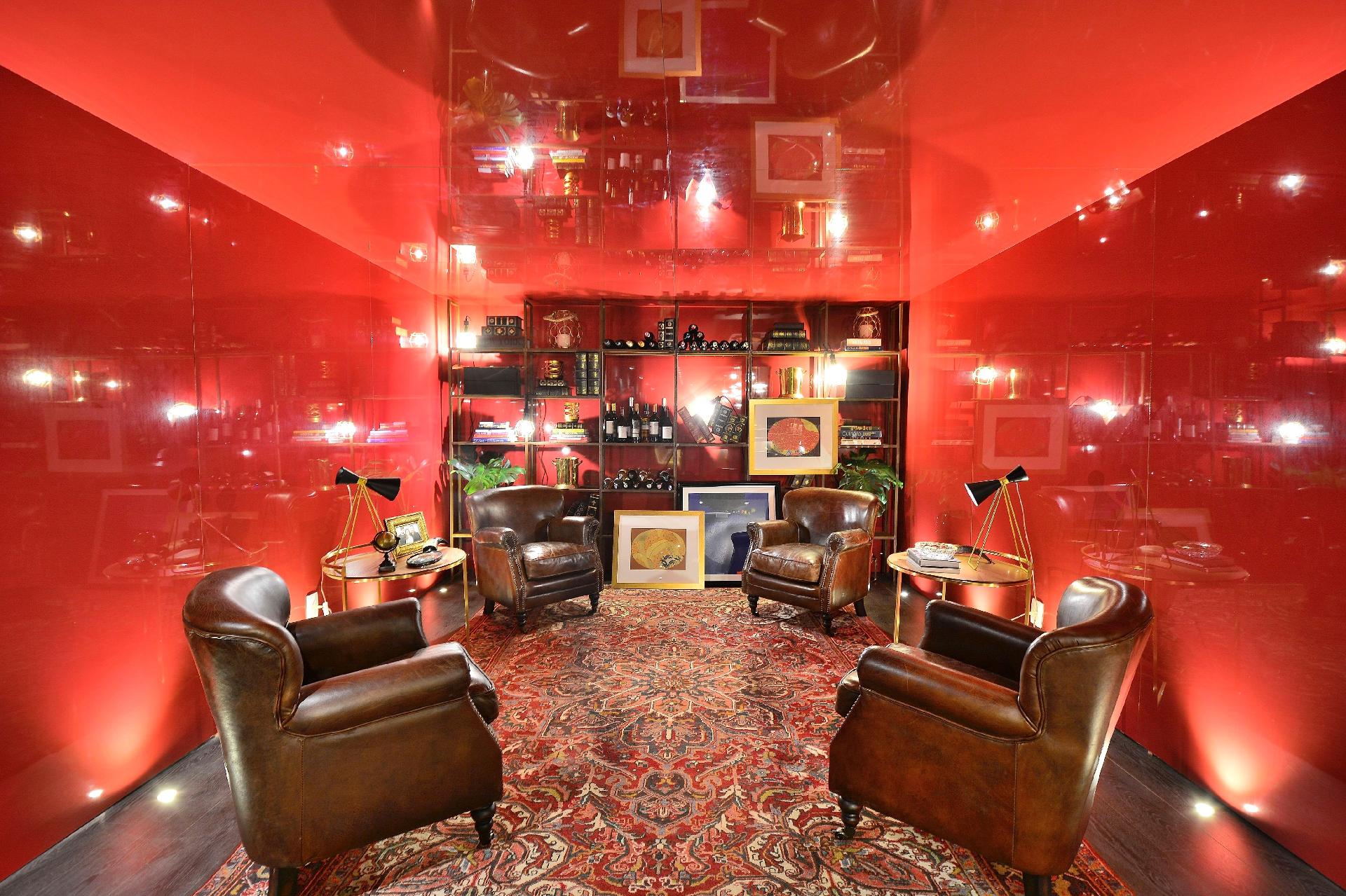 A sala Chef's Table, de Cristina da Luz, Daniel Schon e Juarez Cruz, é um dos 44 espaços da mostra gaúcha. O fundo do ambiente é destinado à degustação de vinho. A estante cria um contraponto com o revestimento do restante do espaço, feito em melamina no padrão Borgonha com alto brilho. As quatro poltronas em couro e as duas mesas de apoio foram dispostas de forma espelhada e completam a decoração - Eduardo Liotti/ Divulgação