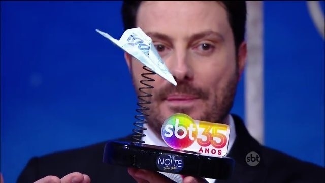 18.ago.2016 - Danilo Gentili mostra o troféu para os ganhadores inspirado nos famosos aviõezinhos de dinheiro distribuídos por Silvio Santos - Reprodução/SBT