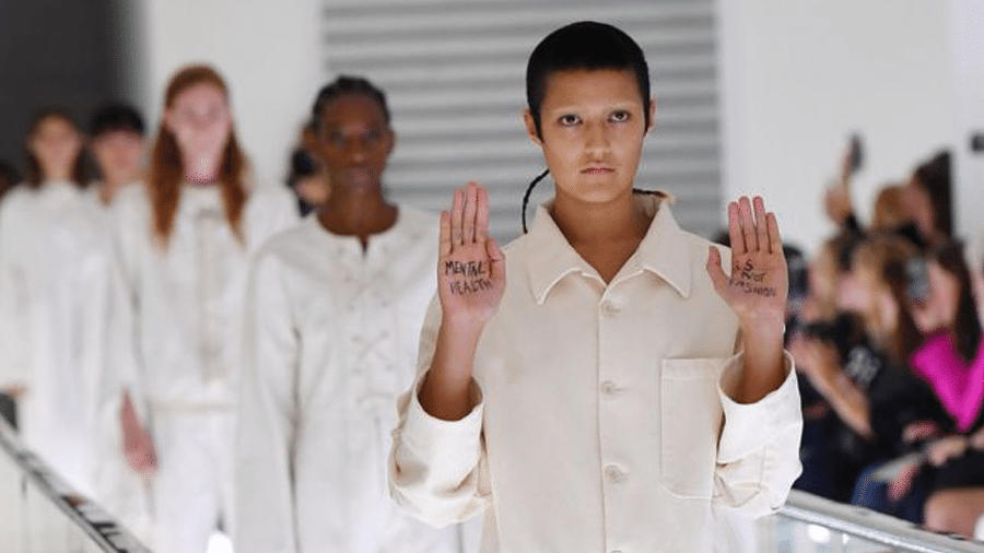 Ayesha Tan-Jones protestou no meio do desfile com uma mensagem escrita na palma das mãos - Getty Images