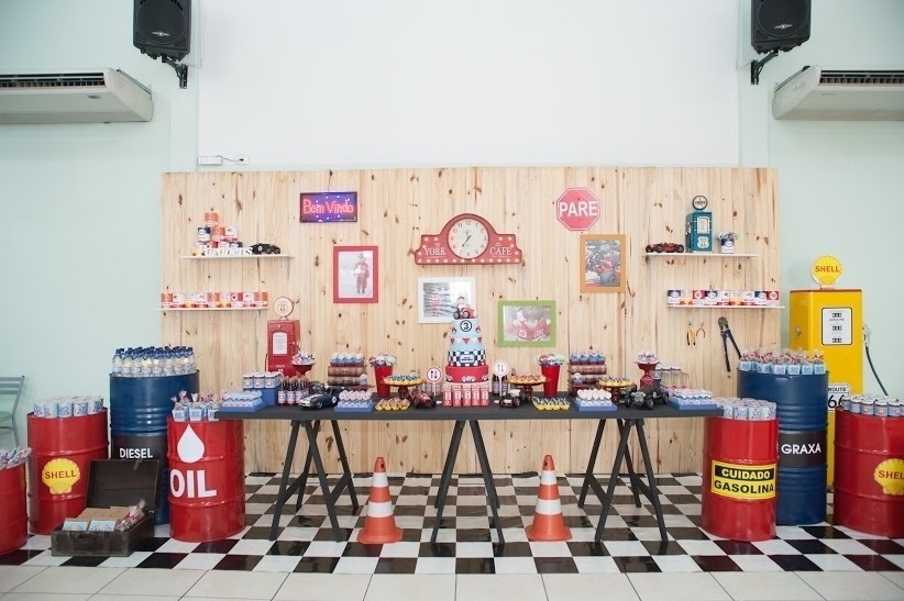 O tema posto de gasolina contou com barris e cones, além de uma mesa de madeira com mais de dois metros de comprimento e três suportes. A decoração é da Brinque Fest (www.brinquefest.com.br) - Divulgação