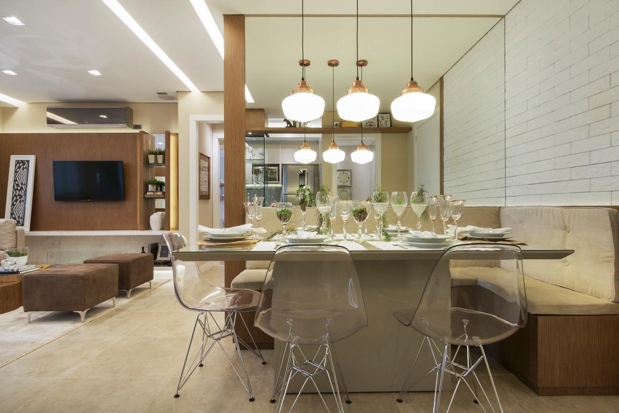 A metragem reduzida para a área de jantar levou a arquiteta Cilene Monteiro Lupi a optar pelo famoso canto alemão, um banco que circula as extremidades da parede em ?L?. Assentos de camurça sintética dão conta do conforto. Já o espelho em uma das paredes ajuda a aumentar visualmente o espaço, assim como a leveza das cadeiras transparentes - Rafael Renzo/Divulgação