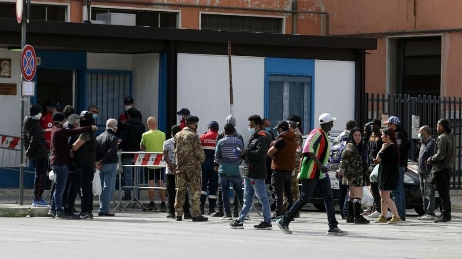 Pessoas na fila para receber a refeição de voluntários em Bari, na Itália - Donato Fasano/Getty Images