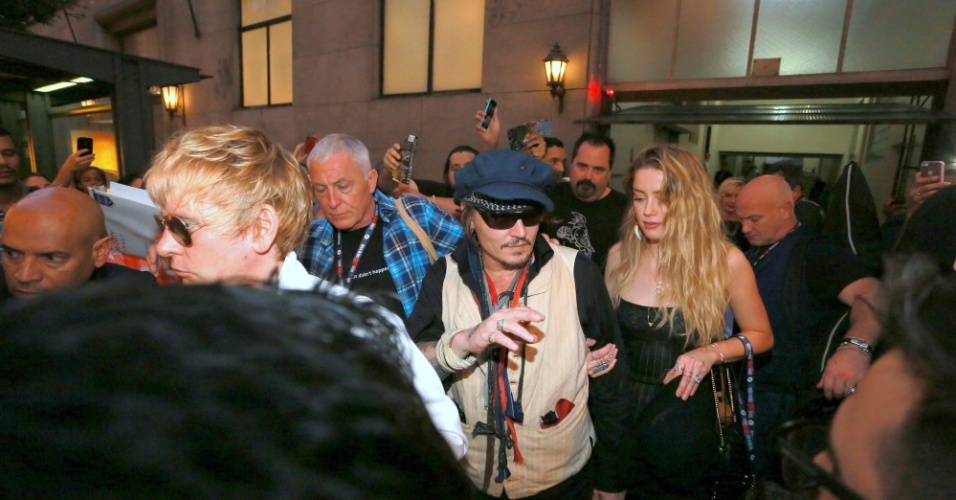 24.set.2015- Acompanhado da mulher, Amber Heard, Johnny Depp acena para fãs ao deixar hotel e seguir para a Cidade do Rock, na zona oeste do Rio de Janeiro. O artista vai se apresentar com a banda Hollywood Vampires no Rock in Rio