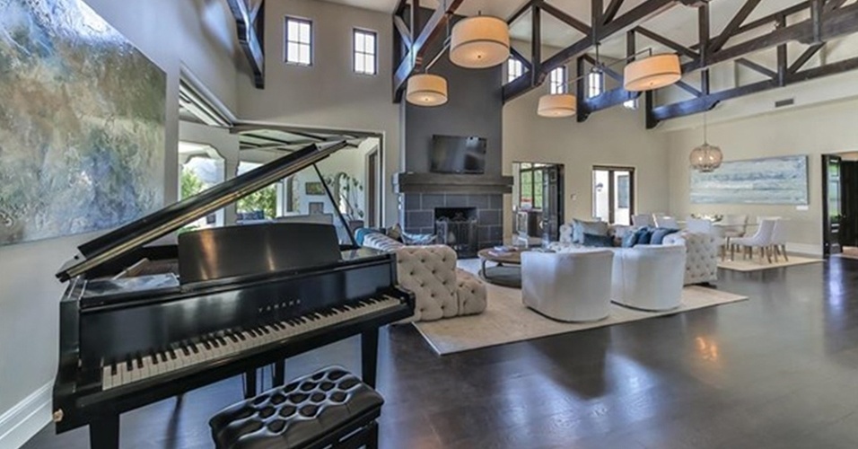 O piano é um dos destaques do segundo ambiente de estar da mansão que Britney Spears está vendendo, por R$ 32 milhões, na Califórnia, Estados Unidos. O espaço conta com móveis claros e blocados: em frente à lareira estão dois sofás em capitonê, duas poltronas e quatro luminária