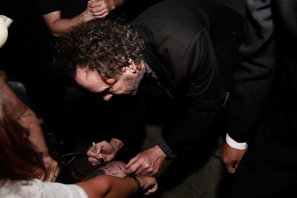 10.fev.2016 - O norte-americano Tim Burton autografa perna de fã durante exposição em sua homenagem no MIS (Museu da Imagem e do Som), em São Paulo - Cláudio Augusto/Brazil News