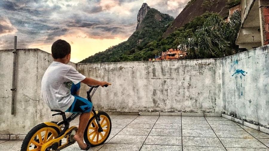 Foto de Elana Paulino na comunidade de Santa Marta mostra menino andando de bicicleta e o Corcovado ao fundo - Arquivo Pessoal