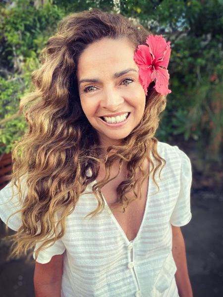 Claudia Ohana posa para foto com flor no cabelo - reprodução/Instagram @ohanareal
