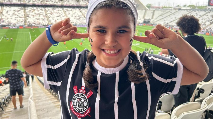 Mirella, de 9 anos, ganhou uma camisa especial do time com o escudo do lado direito, o mesmo onde fica o seu coração. Na foto, ela imita a comemoração do holandês Memphis Depay, atacante do Corinthians