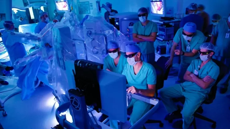 o-urologista-arie-carneiro-mexe-dois-controles-manuais-para-manipular-os-bracos-de-um-novo-robo-cirurgiao-1683562358524_v2_900x506 Robô-cirurgião estreia no Brasil transmitindo operação em 3D