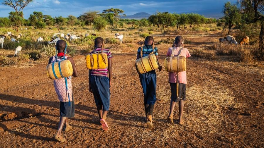 Crianças carregando água do poço, no Quênia