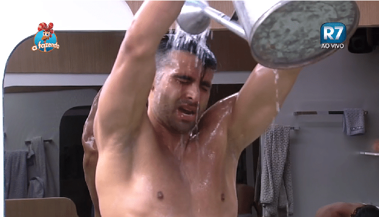 24.set.2015 - João Paulo Mantovani toma banho de regador após peões ficarem sem água encanada - Reprodução/ Record