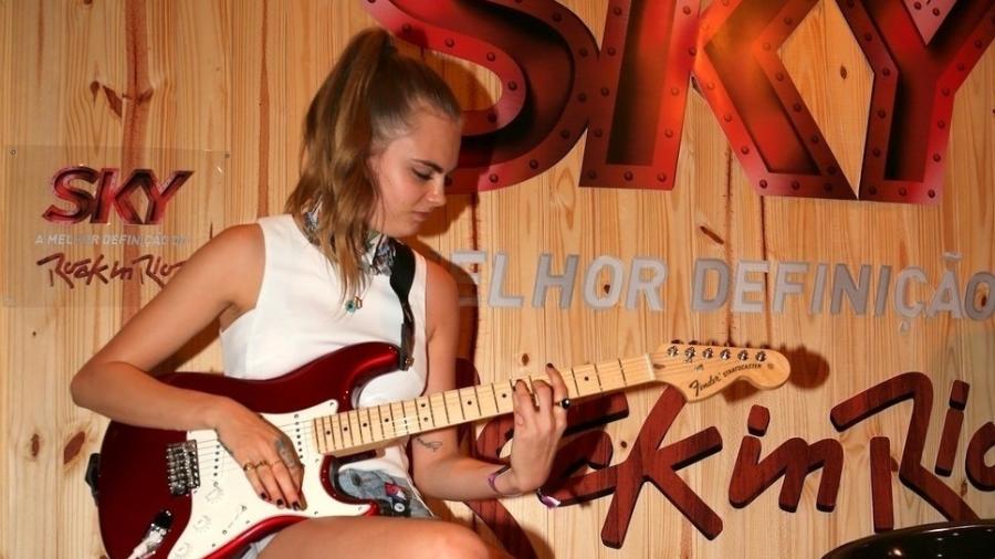 26.set.2015 - Cara Delevingne toca guitarra Fender em camarote do Rock in Rio - AgNews