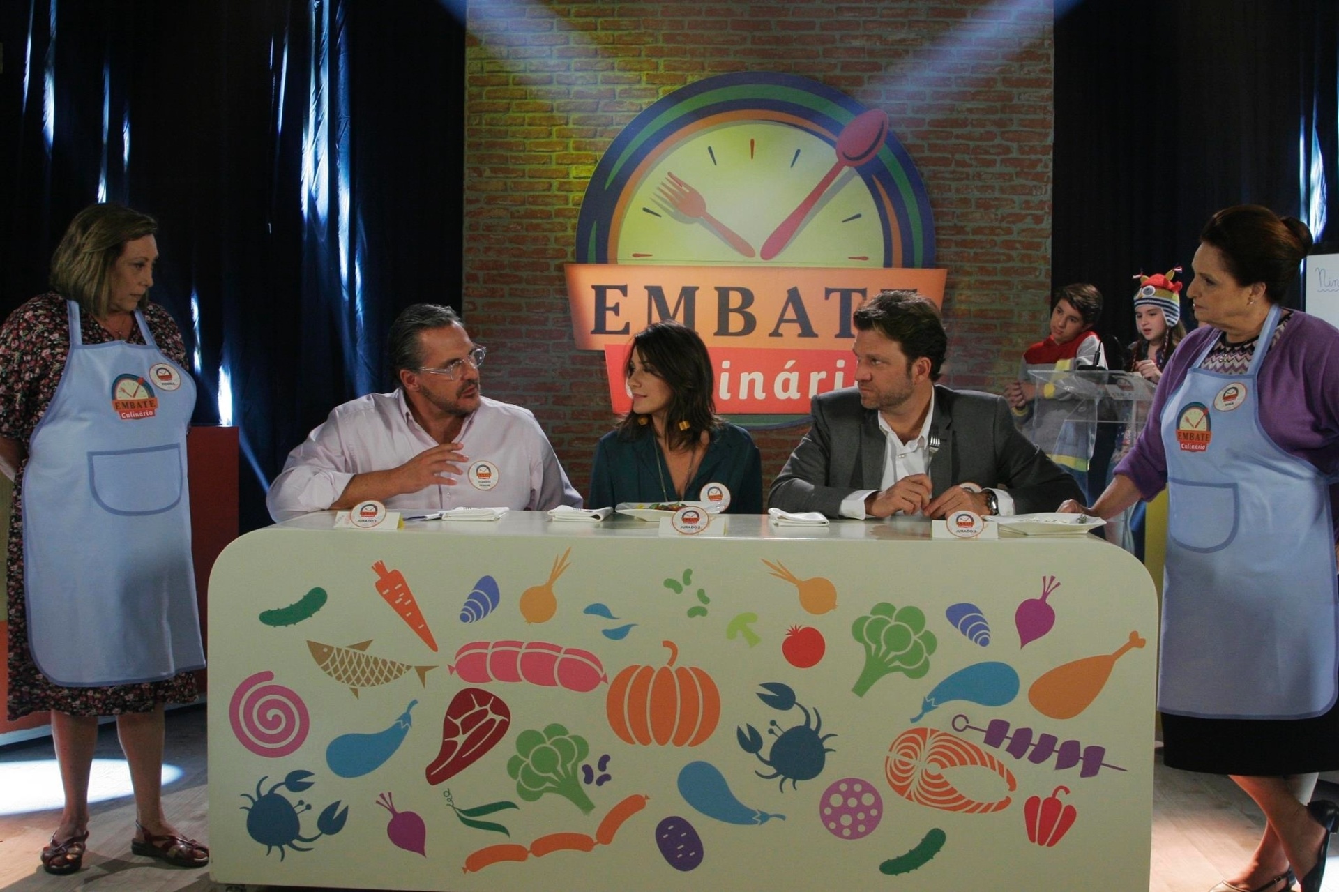 Fabrizio Fasano Jr. e Carol Fiorentino, jurados do "Bake Off Brasil", e Carlos Bertolazzi, apresentador do "Hell's Kitchen" e jurado do "BBQ Brasil", participam de competição de culinária da novela "Cúmplices de um Resgate" no capítulo desta segunda-feira (6) - Cauana Fernandes/SBT