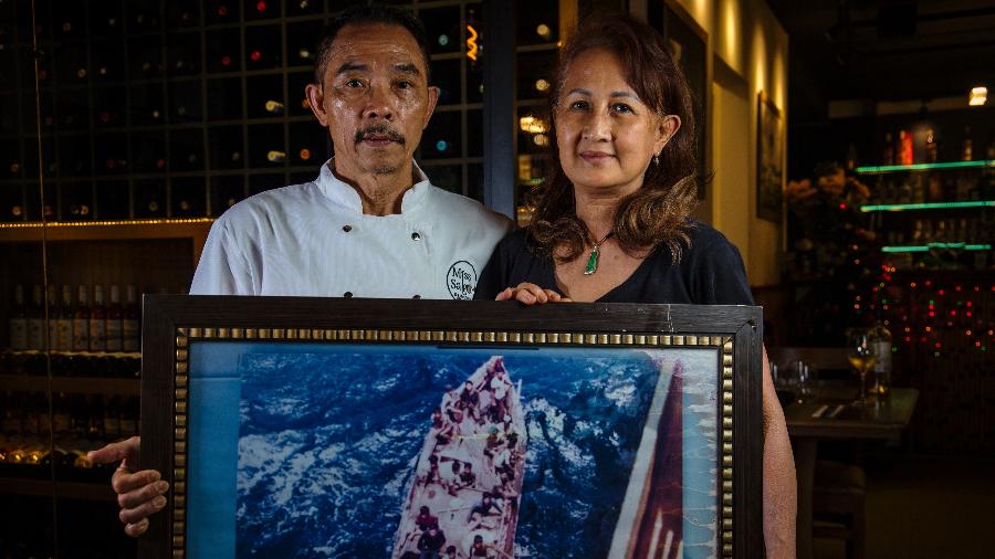  O chef Vo Van Phuoc e sua esposa, Nguyen Thi Kim Dung, com a foto do barco no qual foram resgatados após fugirem do Vietnã - Eduardo Krajan