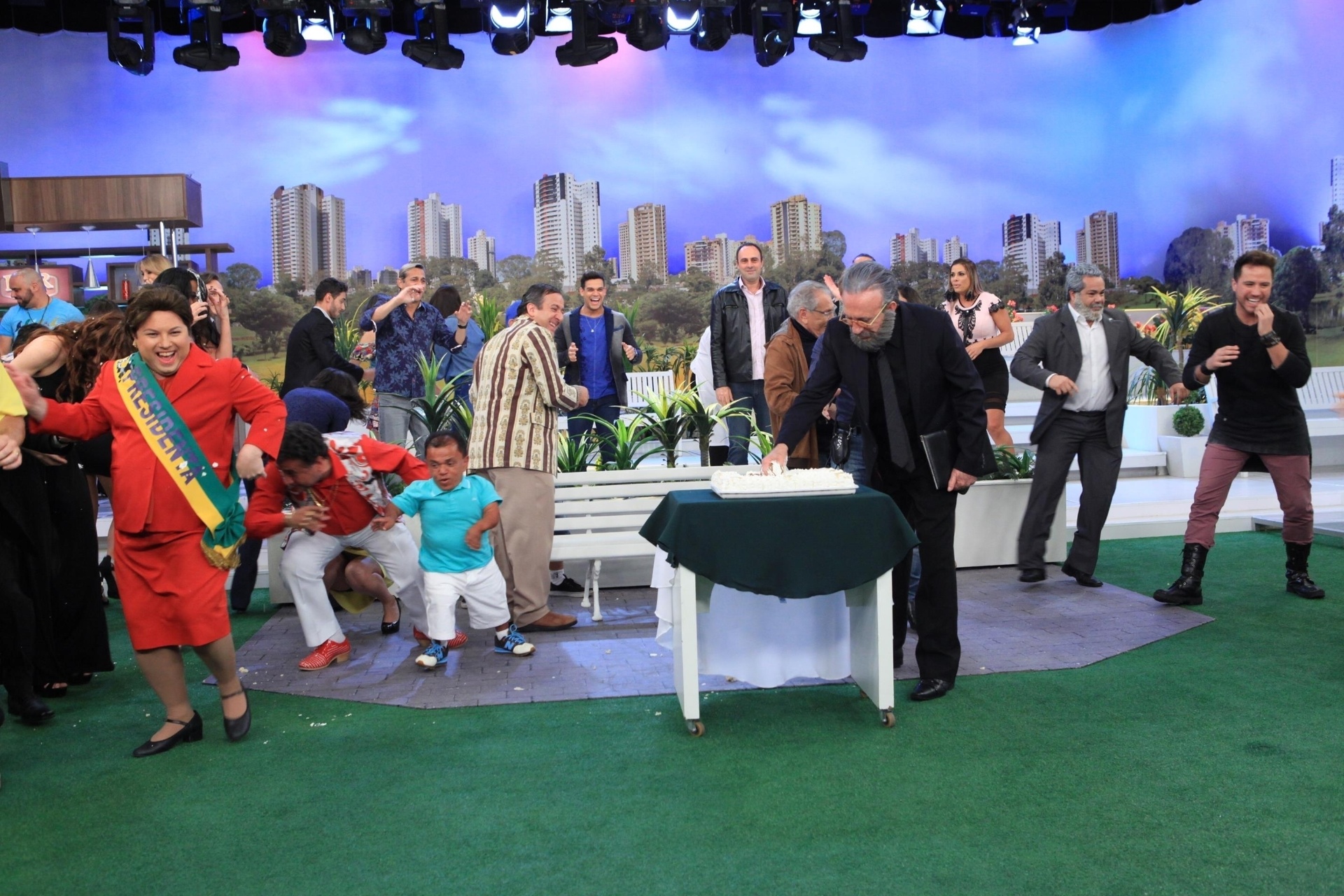 No final da festa surpresa, quando os atores da "Praça" acabaram de cumprimentar e cantar parabéns, Moacyr enfiou a mão no bolo e jogou no elenco. A comemoração, que irá ao ar nesta quinta-feira (6), terminou em "chuva" de bolo - Leonardo Nones/SBT