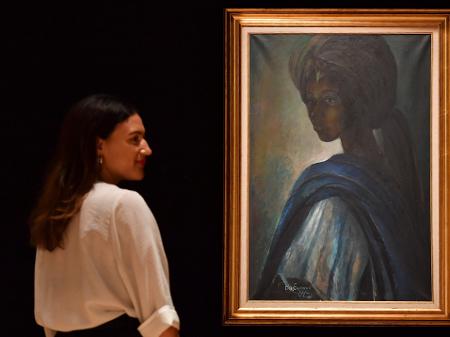 Mulher observa o quadro "Tutu", de Ben Enwonwu, que é chamado de "Mona Lisa africana" - AFP