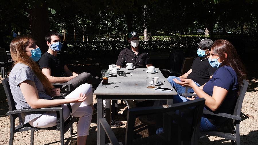 Grupo de pessoas conversa em um café no Parque do Retiro, em Madri - Getty Images