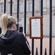 Mulher tira foto do anúncio da morte do príncipe Philip na frente do Palácio de Buckingham - TOLGA AKMEN / AFP